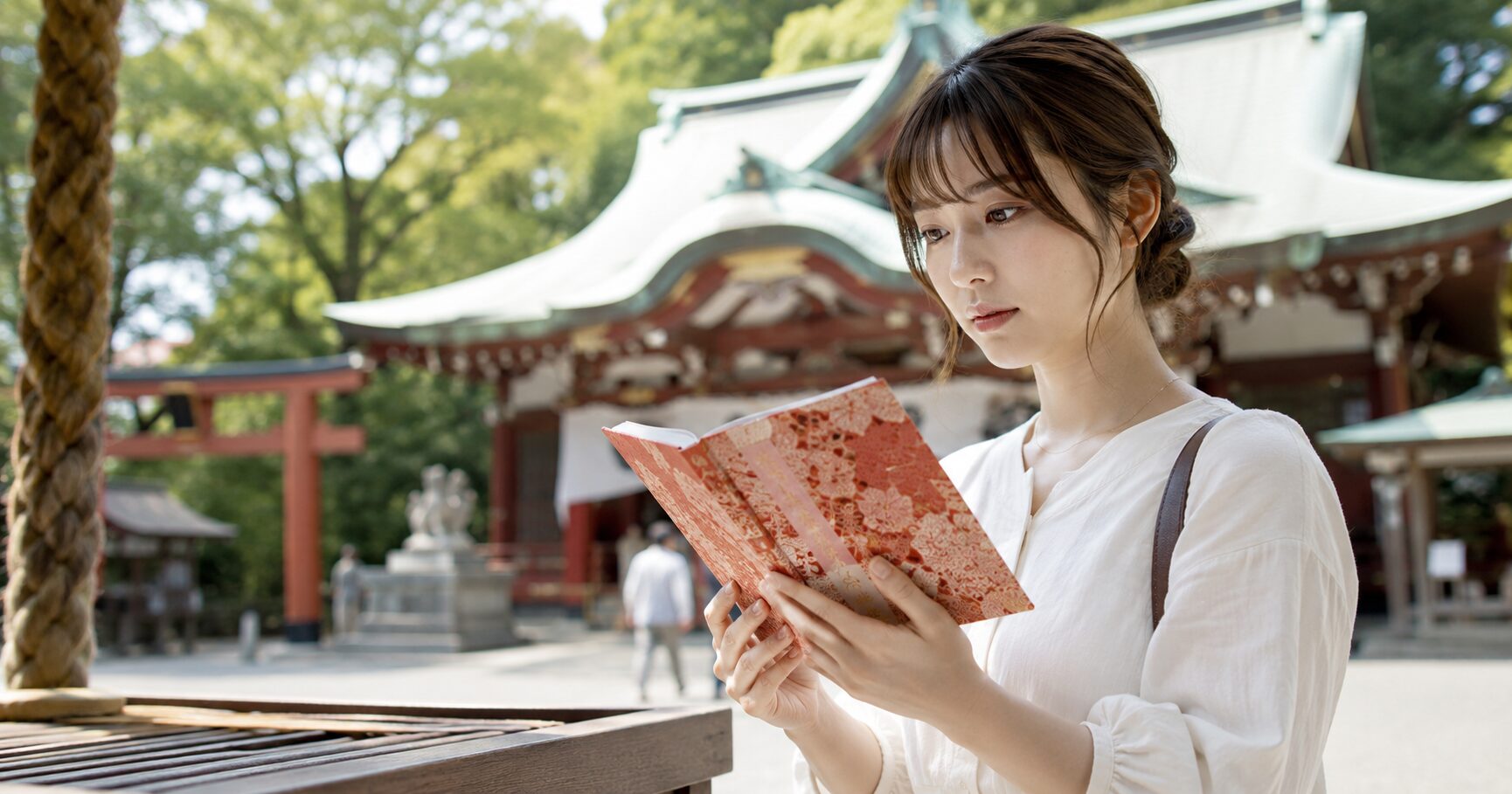 来宮神社の御朱印の口コミを調べつつ、静かな境内で授与された御朱印を手に微笑む女性参拝者の風景